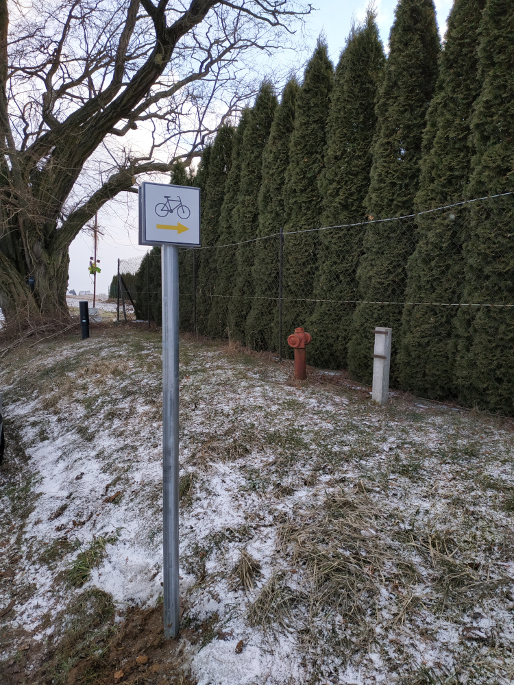 znak szlaku rowerowego: czarny rowerek a poniżej żółta strzałka w prawo