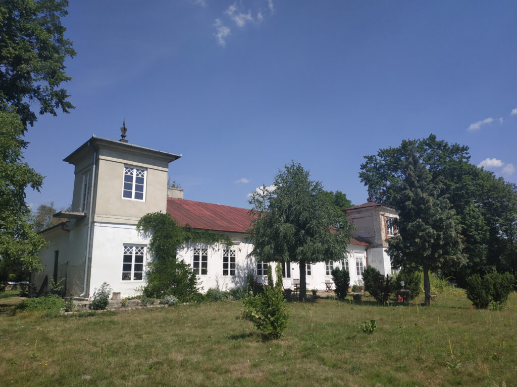 Jasny dworek po bokach niewysokie kwadratowe wieżyczki